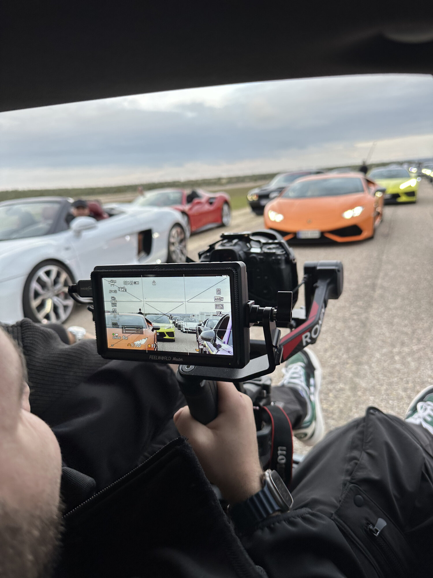 Rig de cámara en pista filmando una fila de superdeportivos