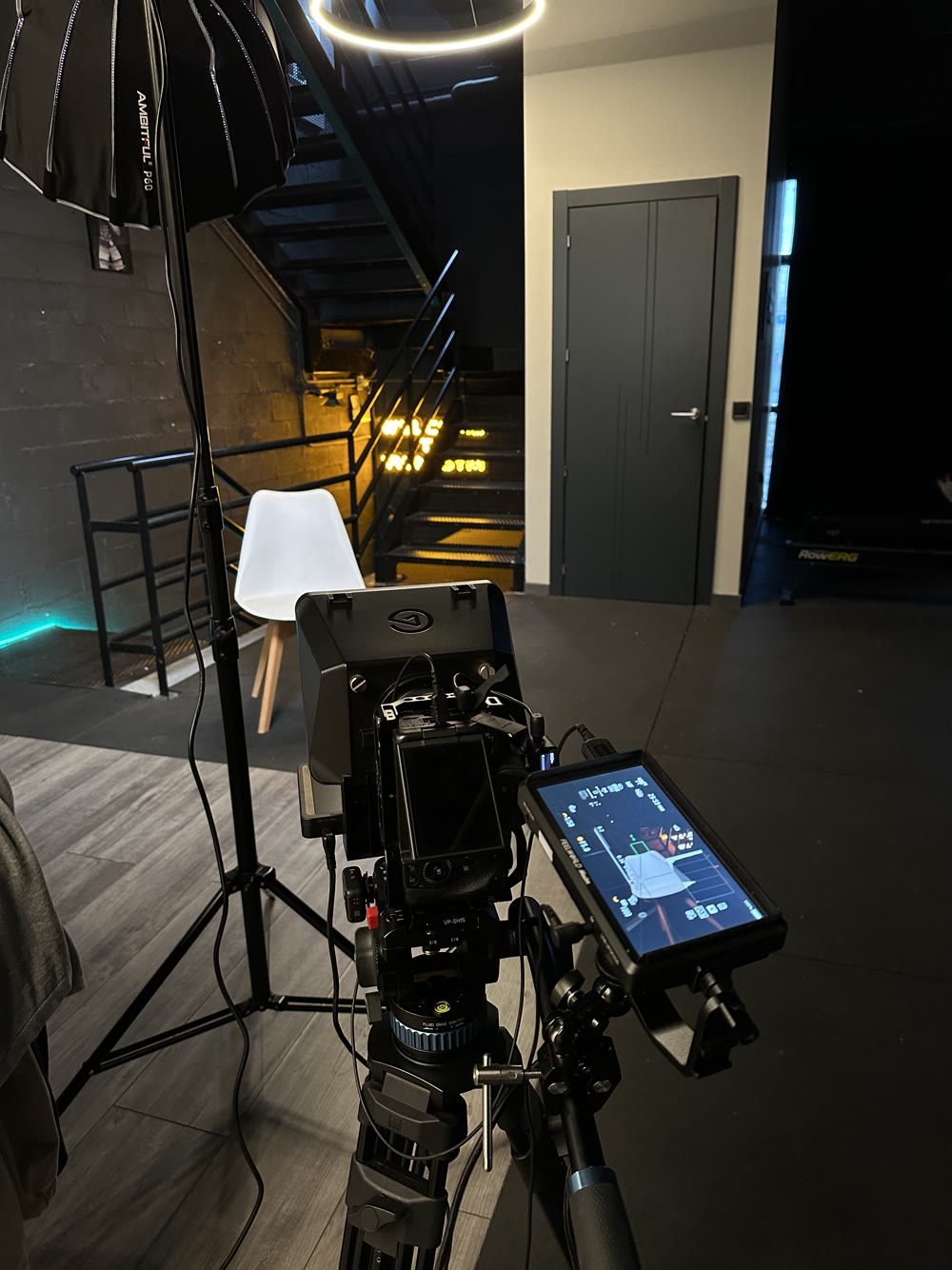 Equipo de cámara y luces frente a una silla en un estudio
