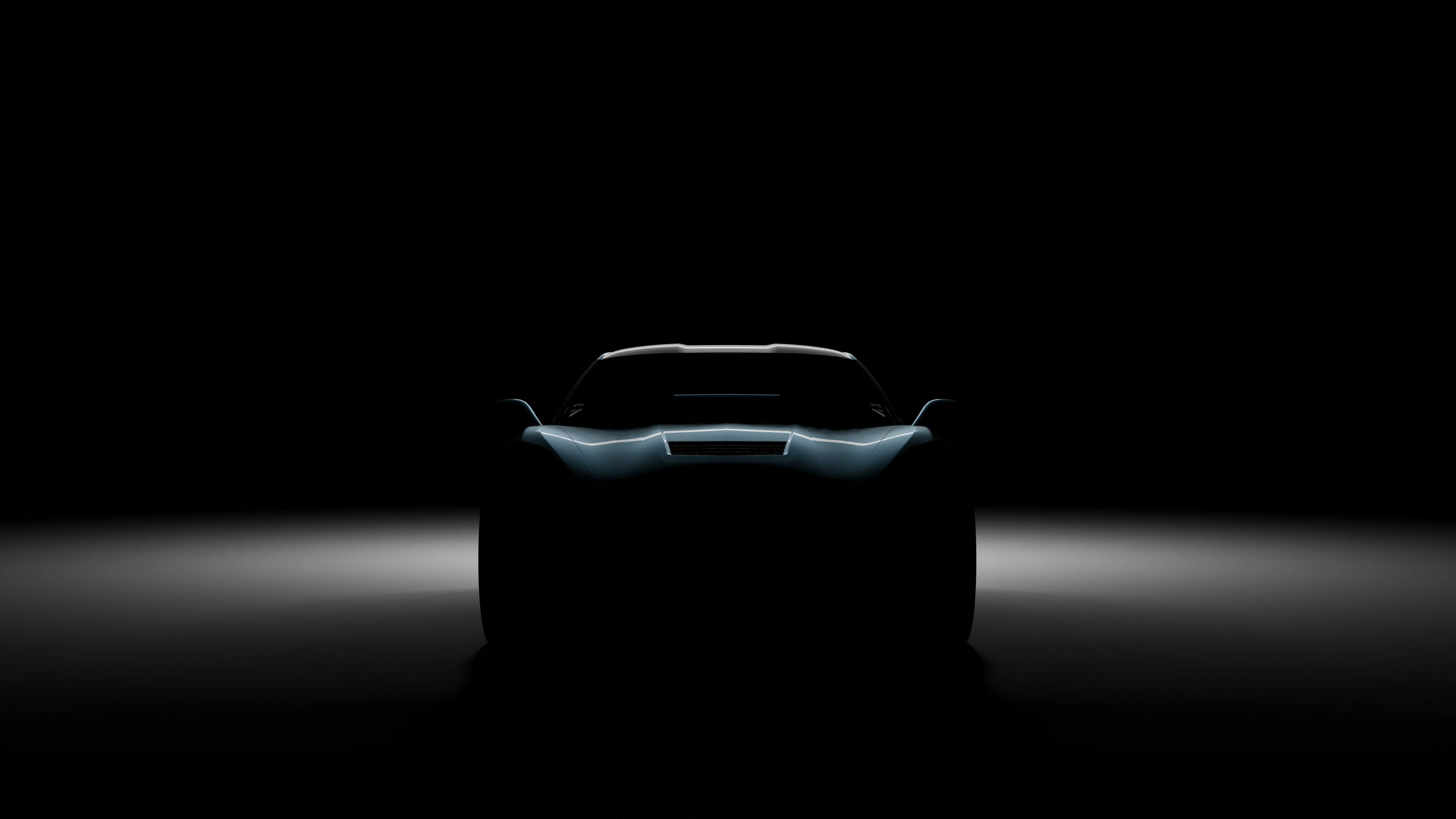 Frontal de un coche deportivo iluminado sobre fondo oscuro